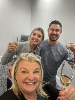Holly Brumm Furdo celebrating closing day with clients, holding champagne